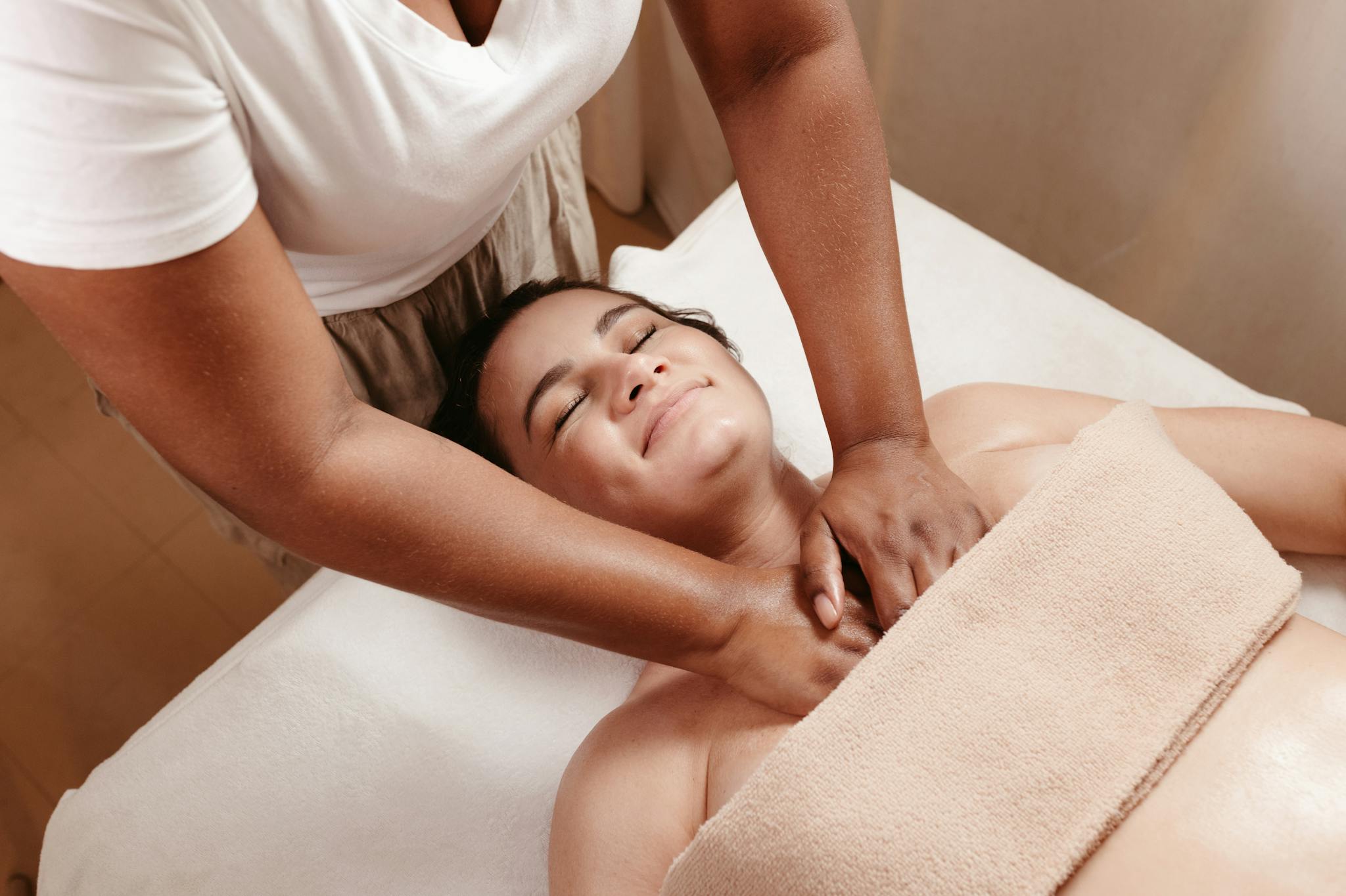 A relaxing spa massage session promoting wellness and peace. Features a smiling woman enjoying therapeutic relief.